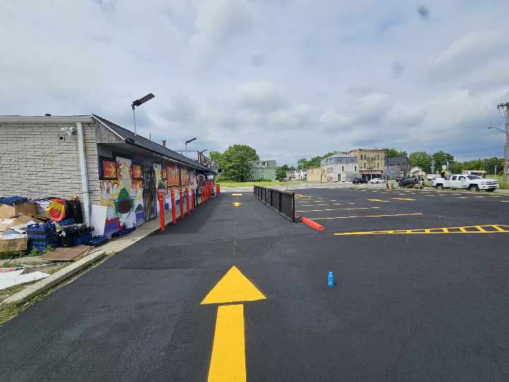 Bold yellow directional arrow striping on a commercial lot